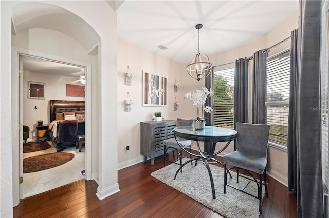 dining area with a chandelier and dark wood-type flooring