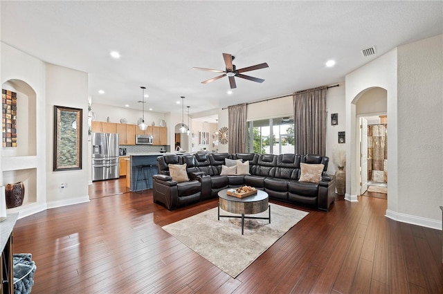 living room featuring ceiling fan and dark hardwood / wood-style flooring