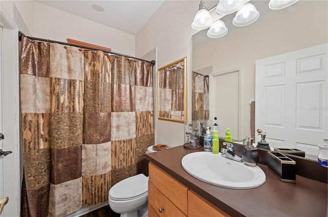 bathroom featuring vanity, toilet, and curtained shower