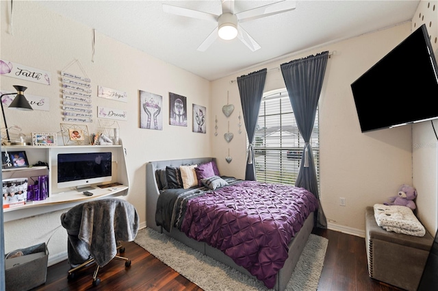 bedroom featuring dark hardwood / wood-style floors, ceiling fan, and built in desk