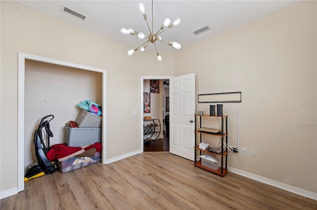 bedroom featuring wood-type flooring and a chandelier