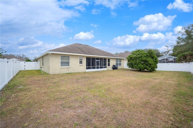 back of house with a yard and a sunroom