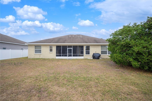 back of property with a yard and a sunroom