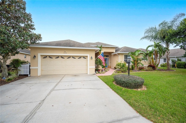 single story home with a garage and a front lawn