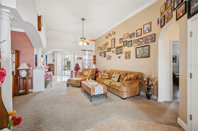 living room with ornate columns, ceiling fan, light colored carpet, and a towering ceiling