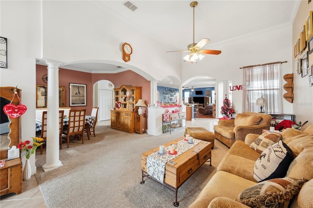 living room with ceiling fan, a high ceiling, ornate columns, and crown molding