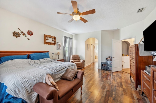 bedroom featuring dark wood-type flooring, a textured ceiling, and ceiling fan