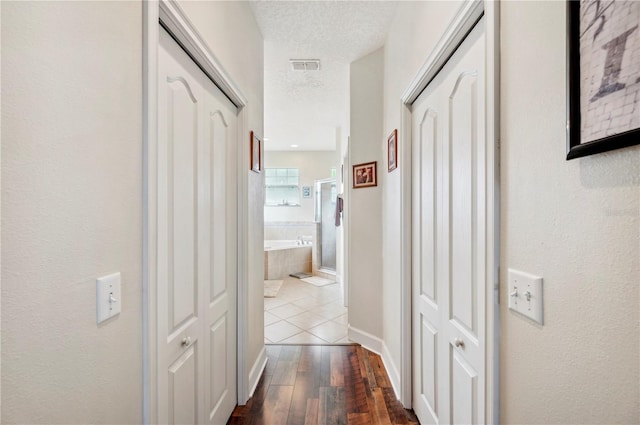 hallway featuring wood-type flooring and a textured ceiling