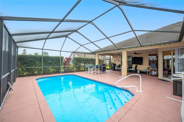 view of swimming pool featuring ceiling fan, a lanai, and a patio