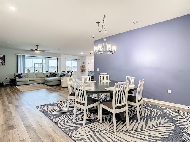 dining room with ceiling fan with notable chandelier and hardwood / wood-style floors