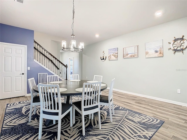 dining space featuring light wood-type flooring and a chandelier