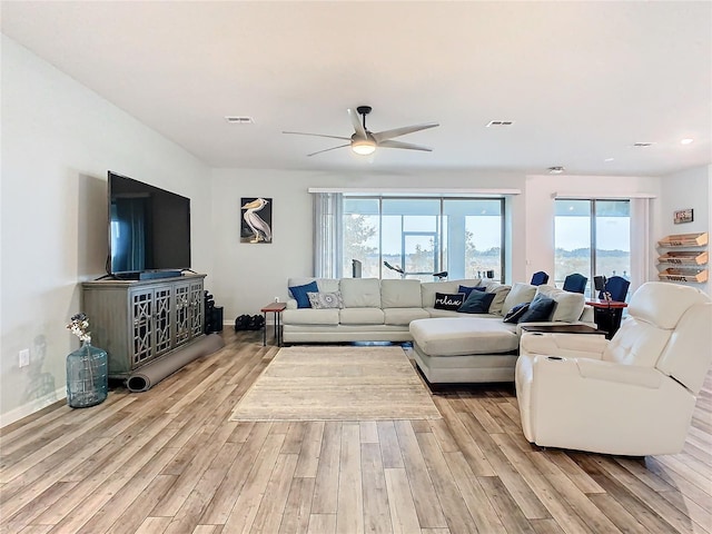 living room with ceiling fan and light hardwood / wood-style flooring