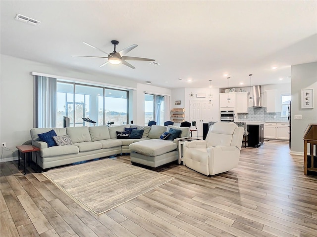 living room featuring ceiling fan and light wood-type flooring