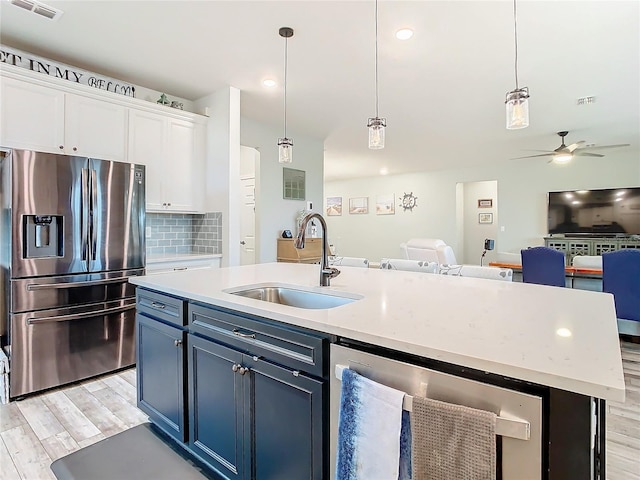 kitchen featuring white cabinetry, stainless steel refrigerator with ice dispenser, sink, backsplash, and a center island with sink