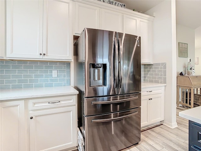 kitchen with backsplash, white cabinets, light hardwood / wood-style flooring, and stainless steel fridge with ice dispenser