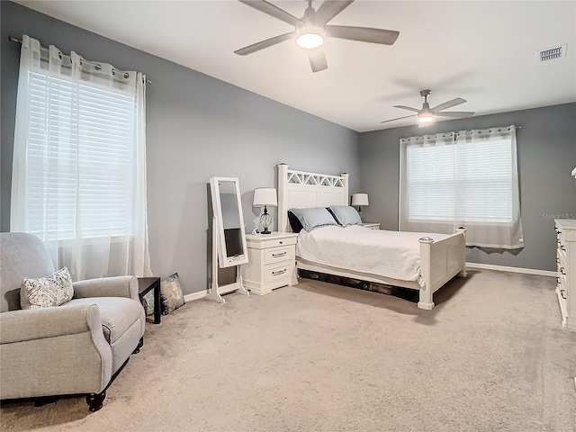 carpeted bedroom featuring multiple windows and ceiling fan