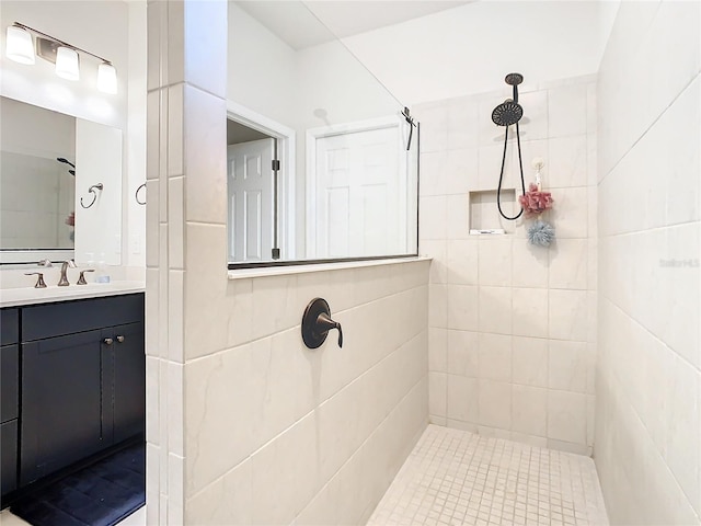 bathroom featuring tiled shower and vanity