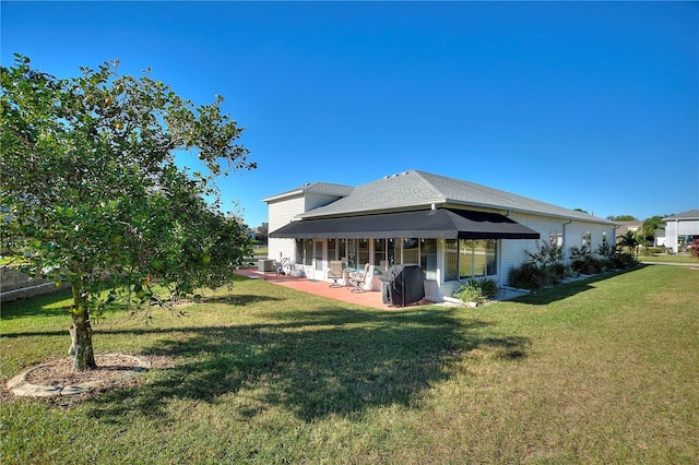 back of house with central AC unit, a patio area, and a lawn