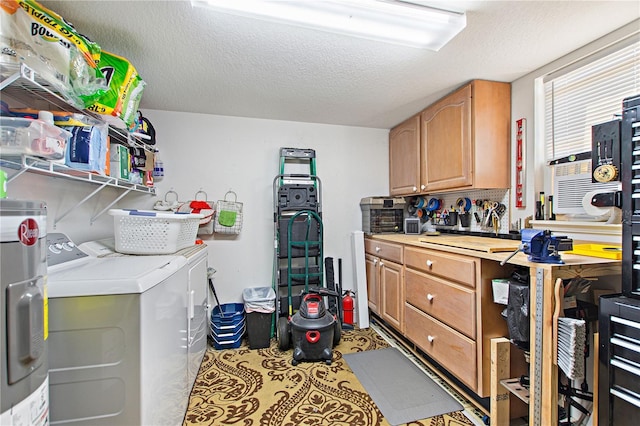 interior space featuring cabinets, independent washer and dryer, water heater, and a textured ceiling