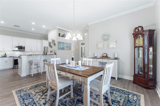 dining room featuring wood-type flooring, ornamental molding, and a chandelier