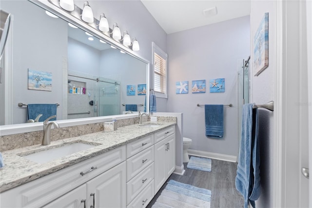 bathroom with vanity, toilet, an enclosed shower, and wood-type flooring