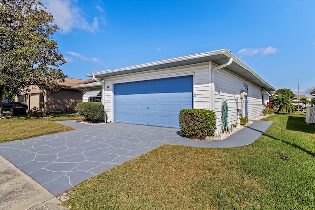 view of side of property featuring concrete driveway, an attached garage, and a yard