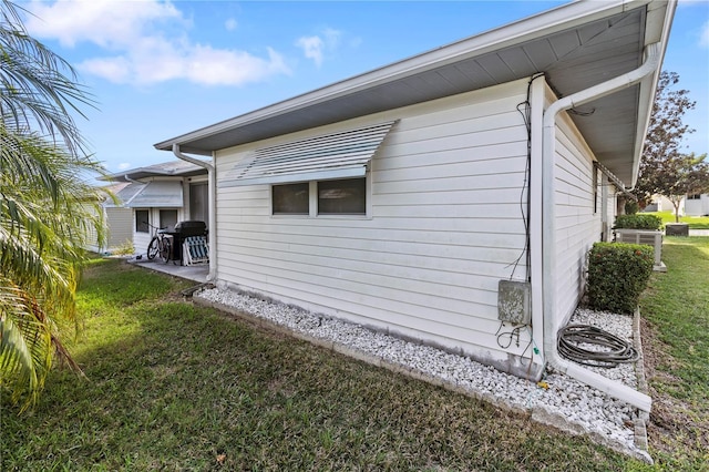 view of home's exterior with a yard and a patio area