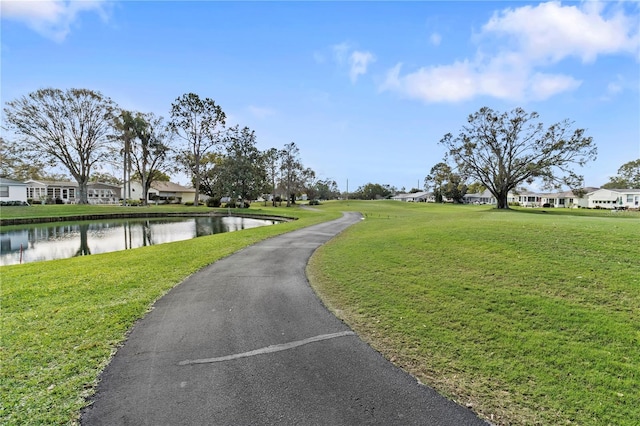 view of property's community featuring a water view, a yard, and a residential view