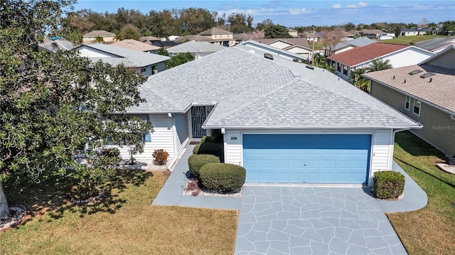 view of front facade featuring a garage, roof with shingles, and a residential view