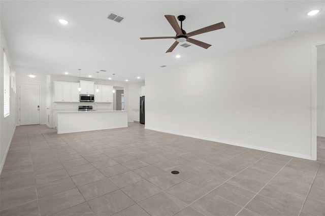 unfurnished living room featuring ceiling fan and light tile patterned flooring