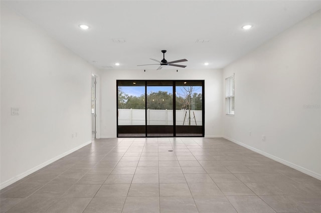 tiled spare room featuring ceiling fan