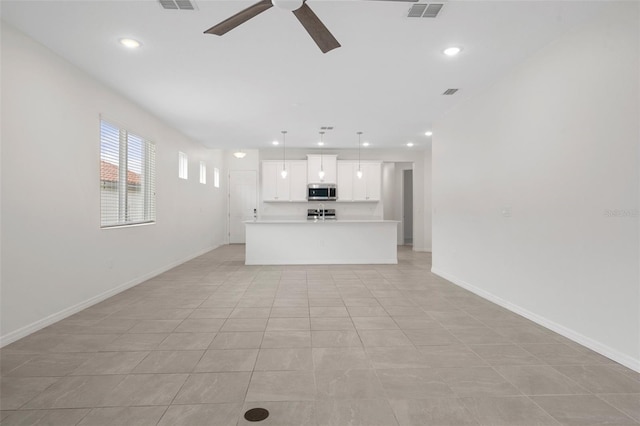 unfurnished living room featuring light tile patterned flooring and ceiling fan