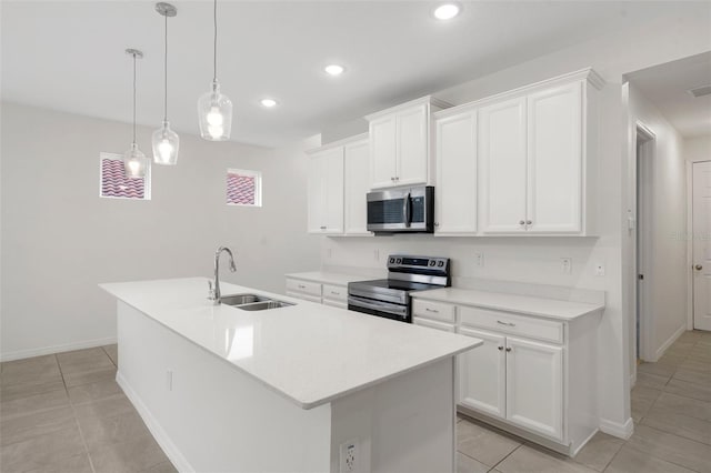 kitchen featuring appliances with stainless steel finishes, sink, white cabinets, pendant lighting, and a center island with sink