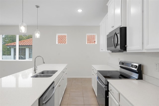 kitchen featuring white cabinets, appliances with stainless steel finishes, sink, hanging light fixtures, and light tile patterned flooring