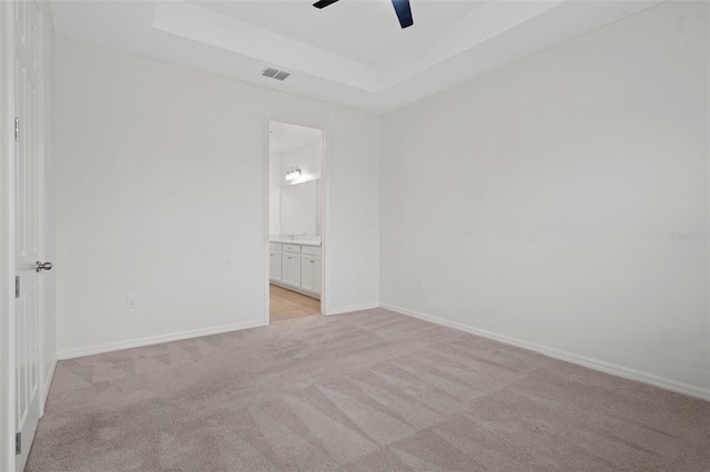 carpeted empty room featuring ceiling fan and a tray ceiling