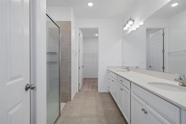 bathroom with tiled shower, tile patterned flooring, and vanity