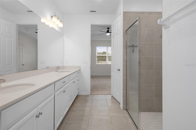 bathroom featuring a tile shower, tile patterned floors, ceiling fan, and vanity