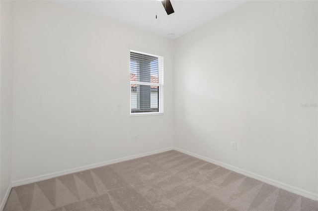 spare room with ceiling fan and light carpet