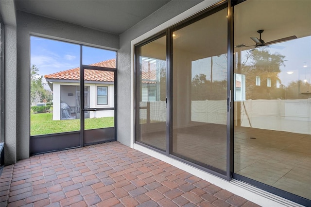 unfurnished sunroom featuring ceiling fan