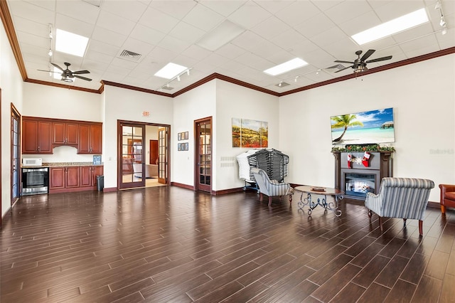 living area with ceiling fan and a towering ceiling