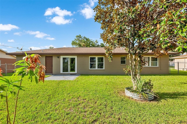 back of house featuring a patio, a lawn, and fence