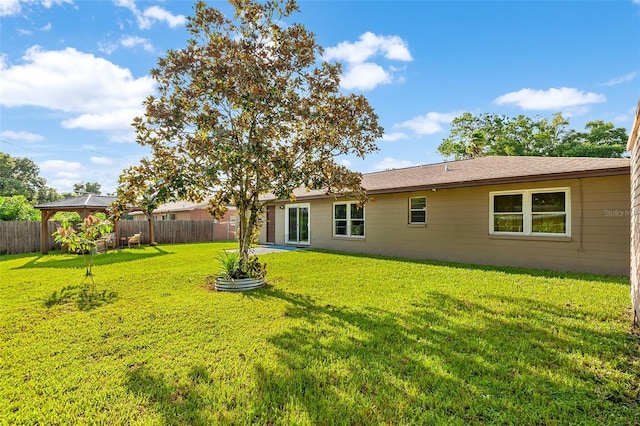 back of house with a fenced backyard, a lawn, and a gazebo