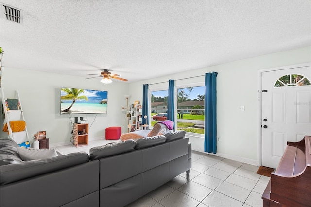 living area featuring a ceiling fan, visible vents, a textured ceiling, and light tile patterned floors