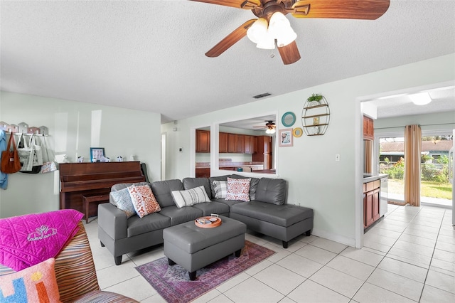 living area with light tile patterned floors, a textured ceiling, and visible vents