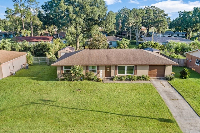 single story home with concrete driveway, an attached garage, fence, a front yard, and stucco siding