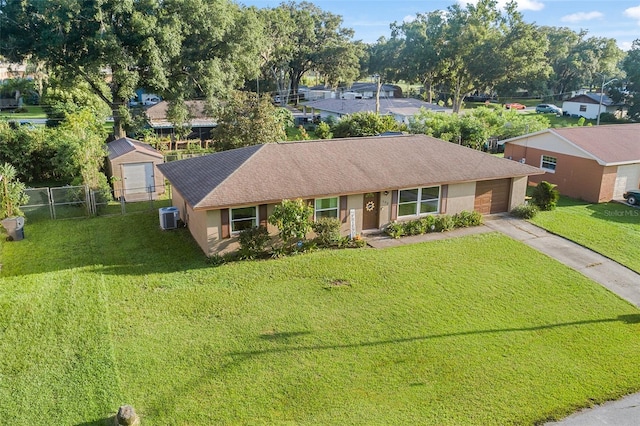 ranch-style house featuring fence, a front lawn, cooling unit, and concrete driveway