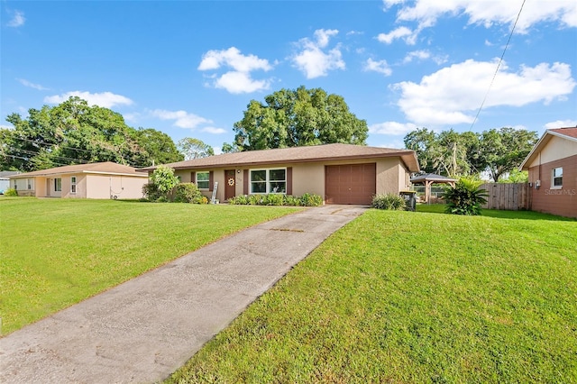 single story home featuring a garage, concrete driveway, fence, a front lawn, and stucco siding