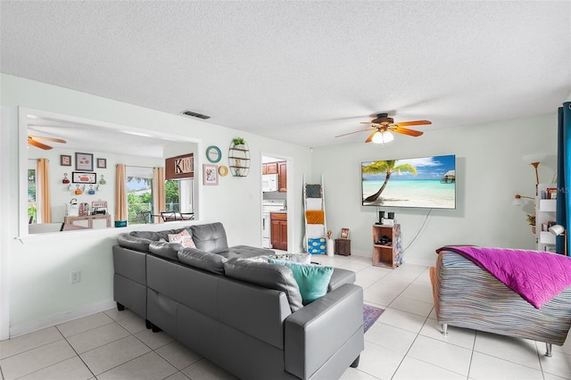 living area featuring light tile patterned floors, ceiling fan, a textured ceiling, and visible vents