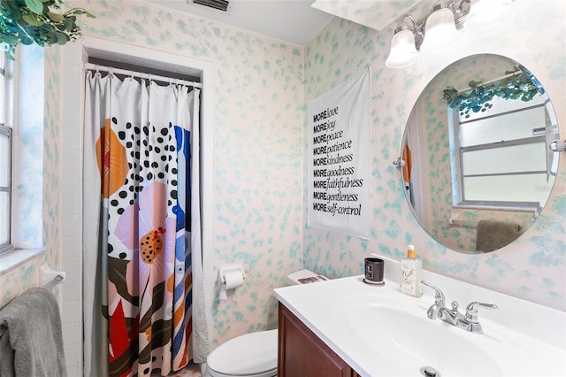 bathroom with vanity, toilet, and wallpapered walls