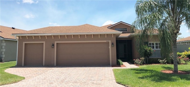 ranch-style house featuring a garage, decorative driveway, a front lawn, and stucco siding